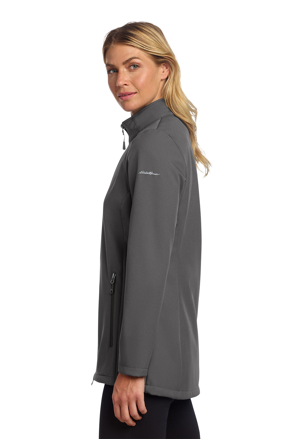 Woman wearing a gray jacket with a visible brand logo on a white background embroidered Eddie Bauer® Women's Stretch Soft Shell Jacket