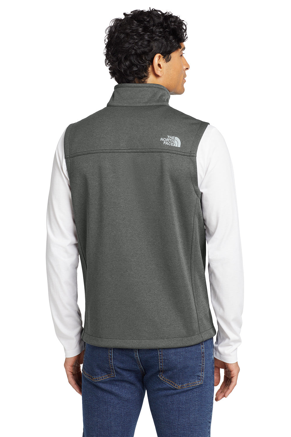 Person wearing a gray vest with a brand logo on the back, white shirt, and blue jeans. Embroidered The North Face® Ridgewall Soft Shell Vest