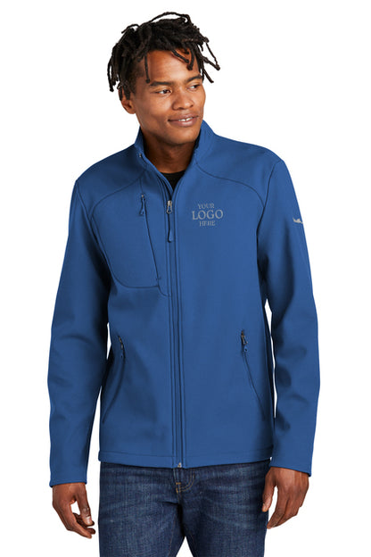Man wearing a blue jacket with a logo on a white background, embroidered Eddie Bauer® Stretch Soft Shell Jacket