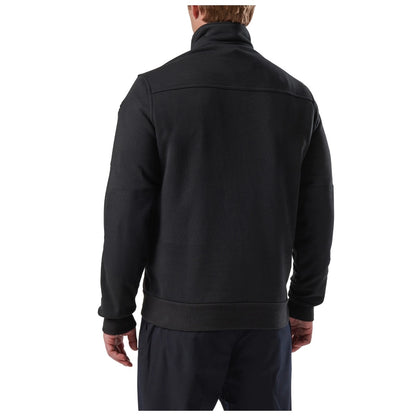 Black jacket worn by a person on a white background. 5.11 Job Shirt 1/4 Zip 2.0, Embroidered by Helmsman Stitch Co.