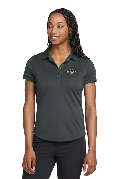 Woman wearing a dark gray polo shirt with 'Your Logo Here' text on a white background, embroidered Nike Women's Dri-FIT Players Modern Fit Polo