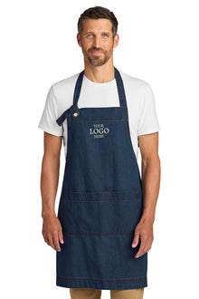 Man wearing a navy blue apron with 'Your Logo Here' text on a white background Port Authority® Signature Denim Apron, Embroidered