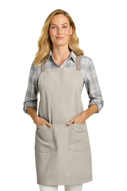Woman wearing a beige apron on a white background. Port Authority® Signature Heavy Twill Crossback Apron, Embroidered