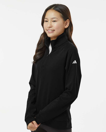 Person wearing a black Adidas sweatshirt on a white background. Adidas Youth Performance Quarter-Zip Pullover, Embroidered by Helmsman Stitch Co.