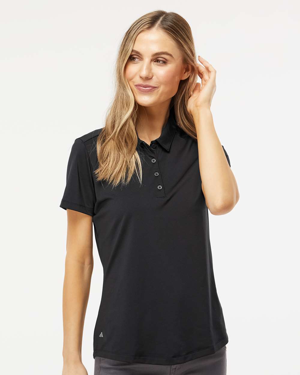 Woman wearing a black Adidas polo shirt on a white background. Adidas Women's Ultimate365 Solid Polo, Embroidered by Helmsman Stitch Co.