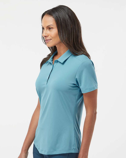 Woman wearing a light blue polo shirt on a white background. Adidas Women's Ultimate365 Solid Polo, Embroidered by Helmsman Stitch Co.