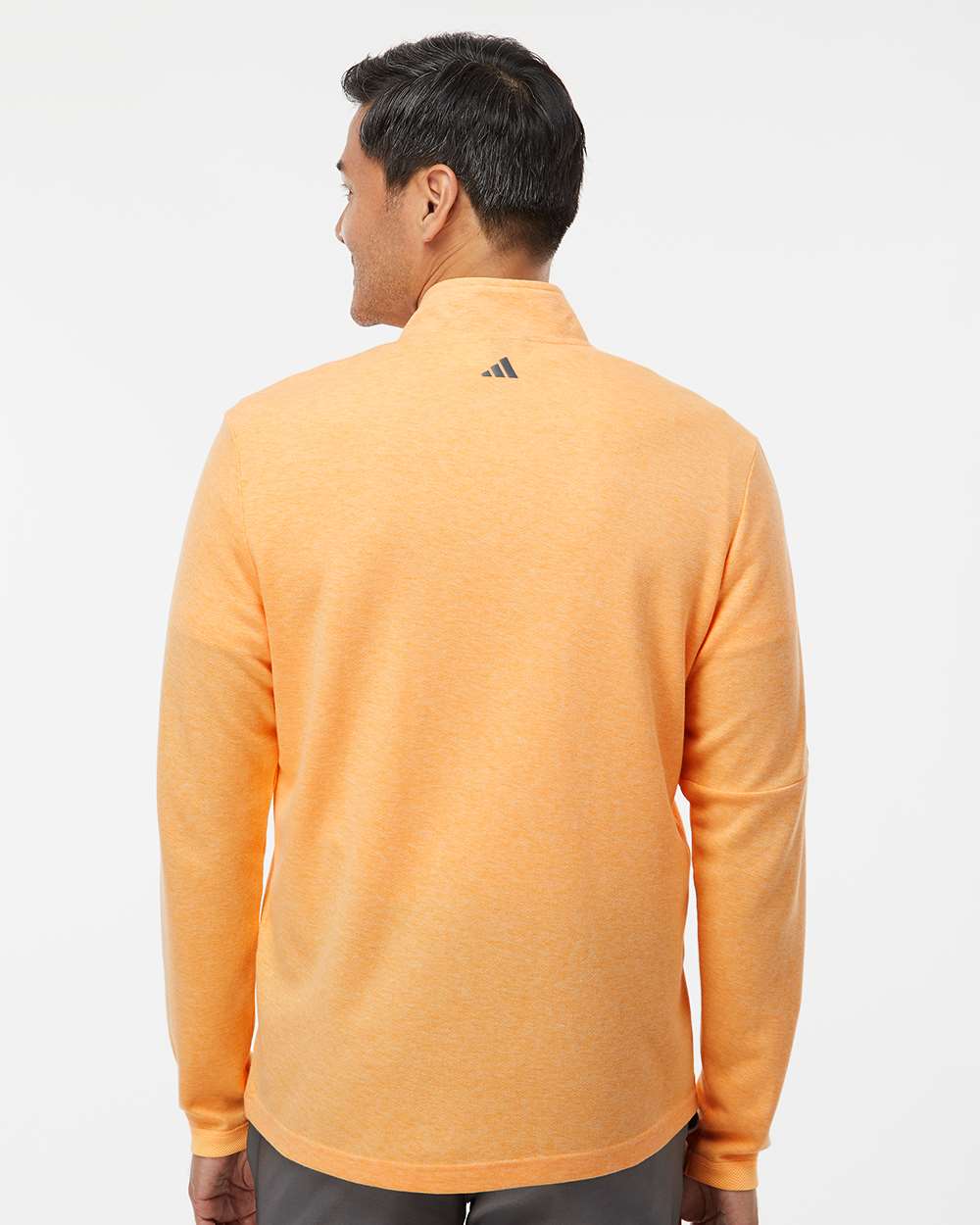 Person wearing an orange Adidas jacket on a white background. Men's 3-Stripes Quarter-Zip Sweater Pullover, Embroidered by Helmsman Stitch Co.