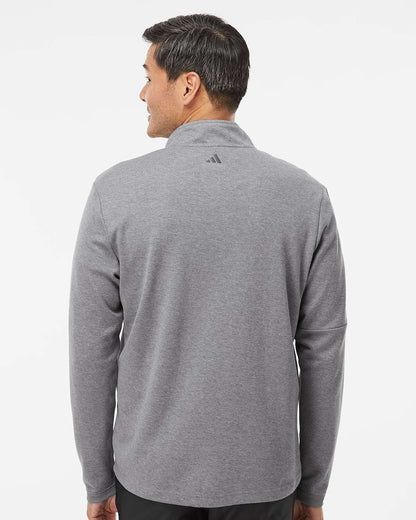 Person wearing a gray Adidas jacket on a white background. Men's 3-Stripes Quarter-Zip Sweater Pullover, Embroidered by Helmsman Stitch Co.