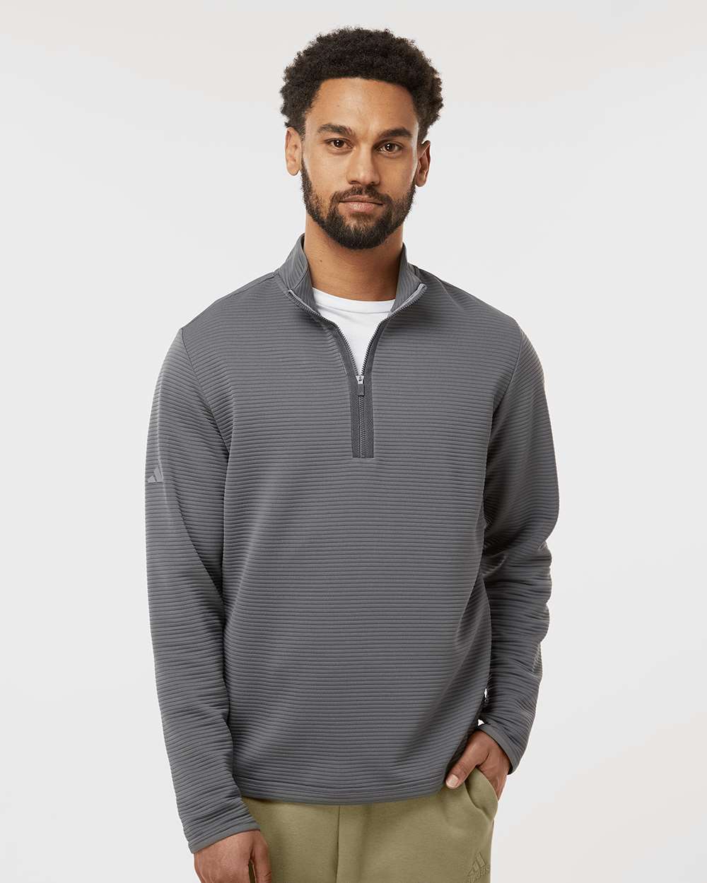 Man wearing a gray striped pullover with a white background. Adidas Men's Spacer Quarter-Zip Pullover, Embroidered by Helmsman Stitch Company