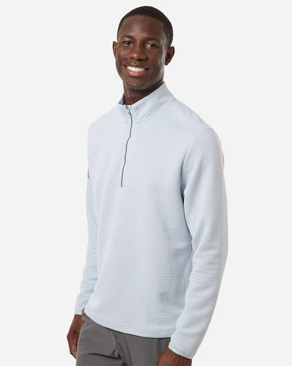 Man wearing a light gray long-sleeve shirt with a quarter zip on a white background. Adidas Men's Spacer Quarter-Zip Pullover, Embroidered by Helmsman Stitch Company