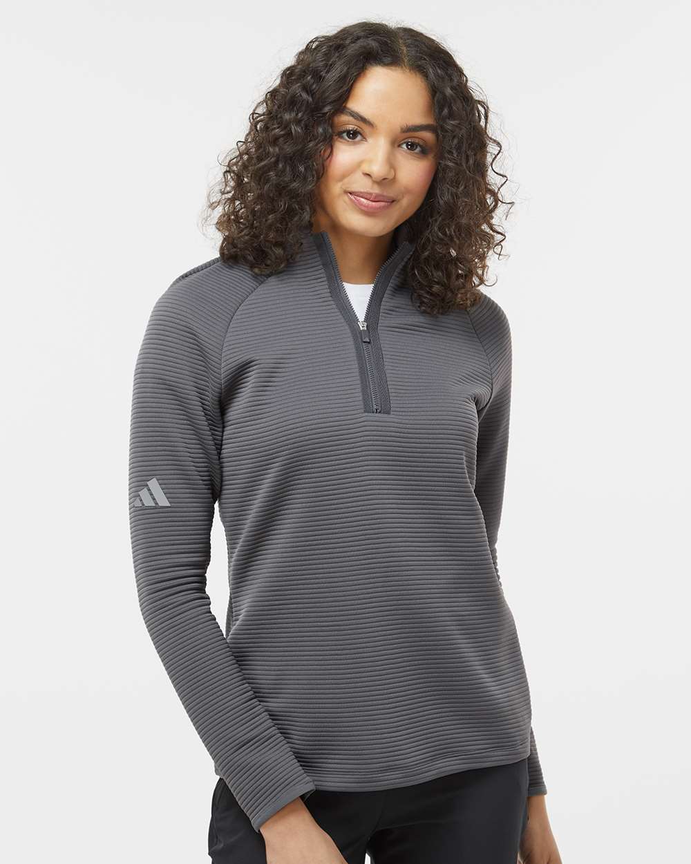 Woman wearing a gray Adidas long-sleeve shirt on a white background. Adidas Women's Spacer Quarter-Zip Pullover, Embroidered by Helmsman Stitch Co.