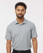 Man wearing a gray Adidas polo shirt against a white background. Adidas Men's Blended Polo, Embroidered by Helmsman Stitch Co.