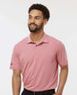 Man wearing a pink Adidas polo shirt against a white background. Adidas Men's Blended Polo, Embroidered by Helmsman Stitch Co.