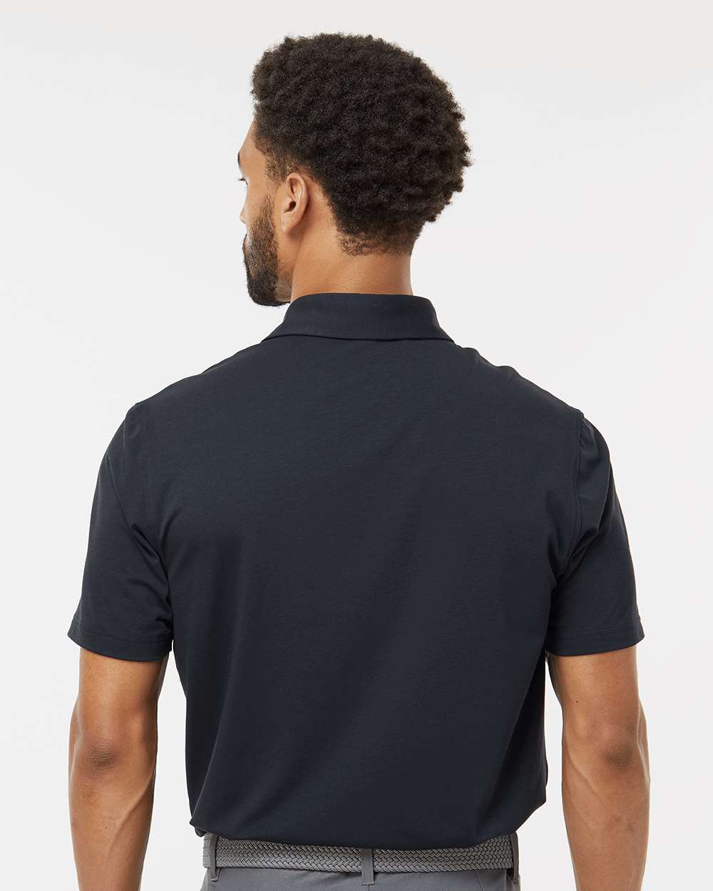 Man wearing a black polo shirt on a white background. Adidas Men's Blended Polo, Embroidered by Helmsman Stitch Co.