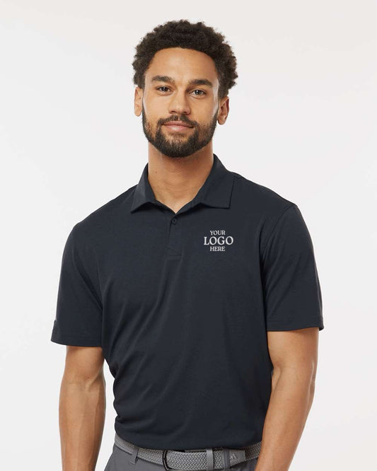 Man wearing a black polo shirt with customizable text on a white background. Adidas Men's Blended Polo, Embroidered by Helmsman Stitch Co.