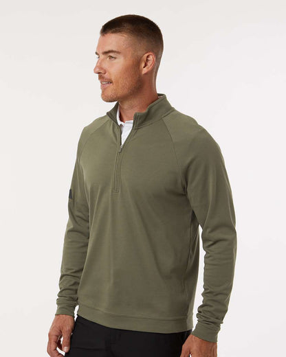 Man wearing a green half-zip pullover on a white background. Adidas Men's Club Quarter-Zip Pullover, Embroidered by Helmsman Stitch Co.