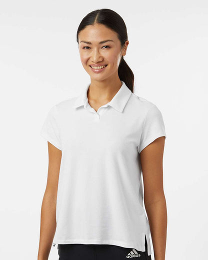 Woman wearing a white Adidas polo shirt on a white background. Adidas Women's Blended Polo, Embroidered by helmsman Stitch Co.