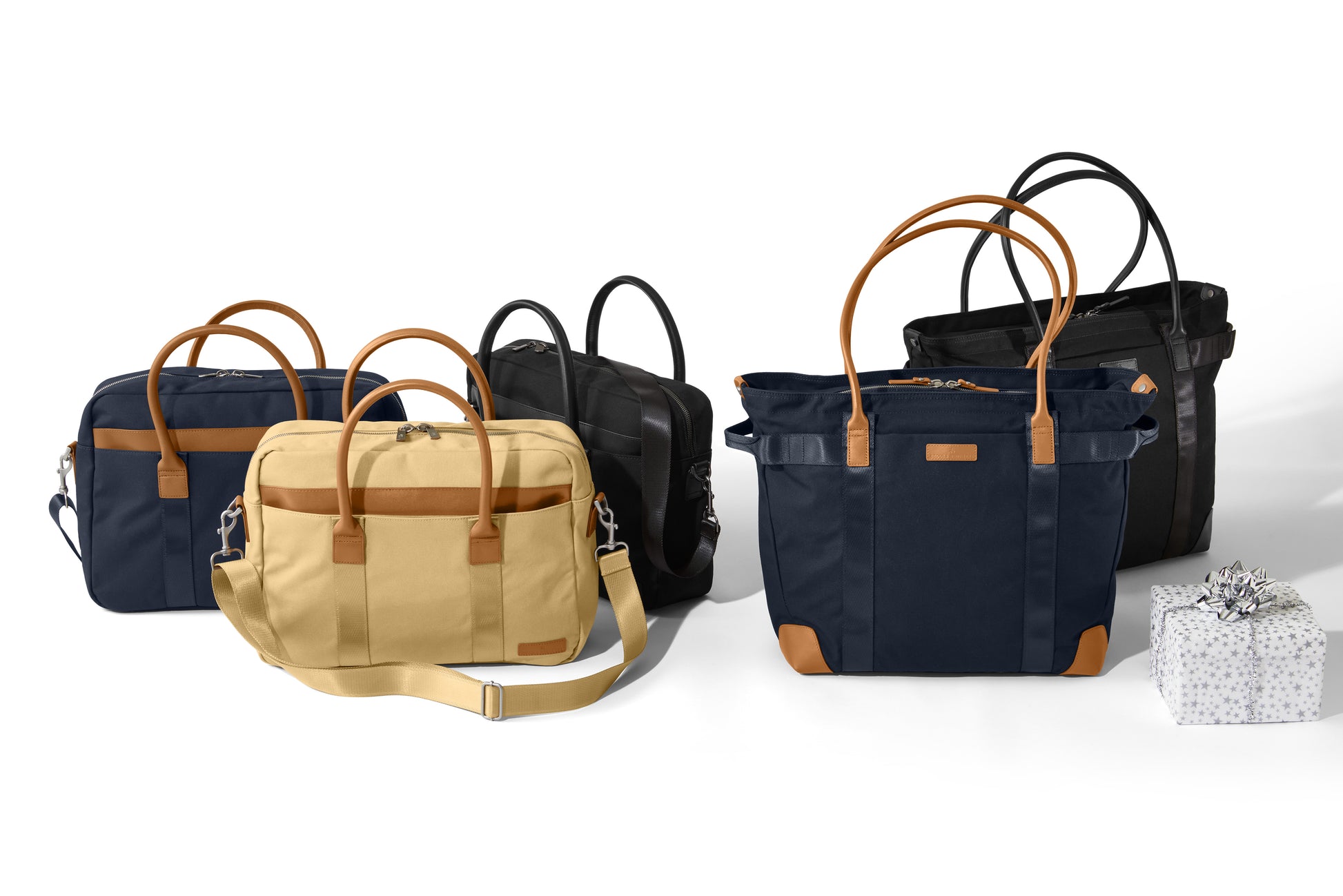 Collection of bags including a navy briefcase, beige satchel, and black and blue handbags on a white background. embroidered Brooks Brothers® Wells Briefcase
