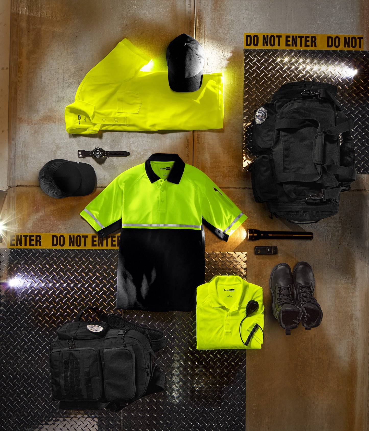 Collection of safety gear including a high-visibility shirt, pants, boots, and a helmet on a reflective surface with 'Do Not Enter' tape. CornerStone® Select Lightweight Snag-Proof Enhanced Visibility Polo, Embroidered