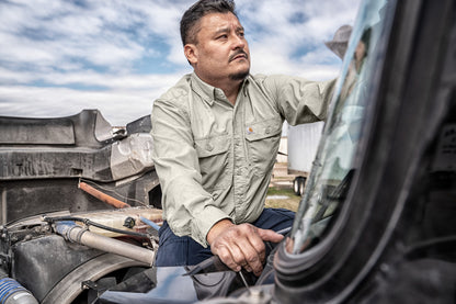 Man working on a vehicle with a clear sky background embroidered Carhartt Force® Solid Long Sleeve Shirt