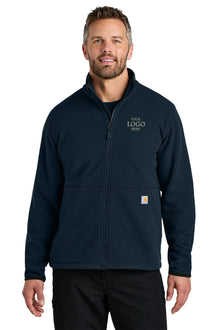 Man wearing a navy blue jacket with a customizable logo area on a white background embroidered Carhartt® Textured Full-Zip Fleece Jacket