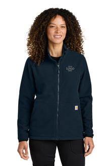 Person wearing a navy blue jacket with a logo on a white background embroidered Carhartt® Women’s Textured Full-Zip Fleece Jacket
