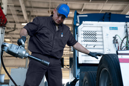 Mechanic working on a vehicle tire in a garage