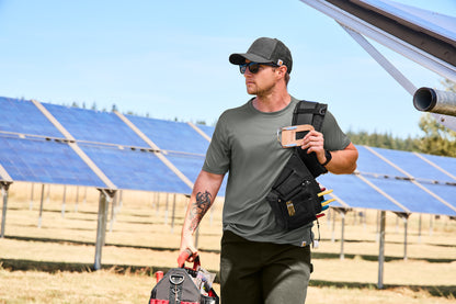 Person carrying a tool bag in front of solar panels, Carhartt® Rugged Professional™ Series Cap, Embroidered