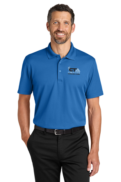 Man wearing a blue polo shirt with a logo on a white background. Port Authority® Plaited Pique Polo, Creative Technologies Academy embroidered by Helmsman Stitch Co.