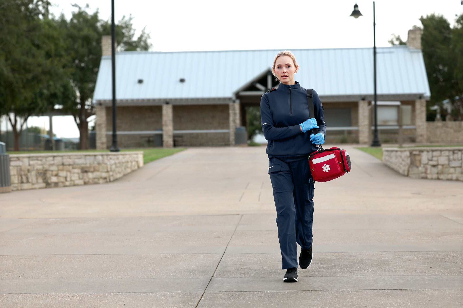 Person in uniform walking outdoors with a first aid kit, Carhartt® Women’s FLD & RSCU 1/2-Zip Mid-Layer, Embroidered