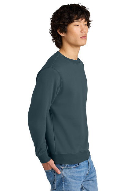 Man wearing a dark green sweatshirt and blue jeans on a white background, Embroidered District® Perfect Weight® Fleece Crew