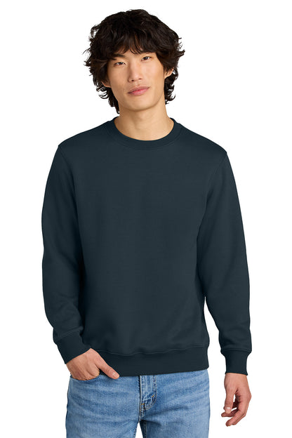 Person wearing a navy blue sweatshirt and light blue jeans on a white background, Embroidered District® Perfect Weight® Fleece Crew