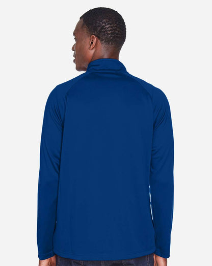 Person wearing a blue long-sleeve shirt on a white background. Devon & Jones Men's Stretch Tech-Shell® Compass Quarter-Zip Pullover, Embroidered by Helmsman Stitch Co.