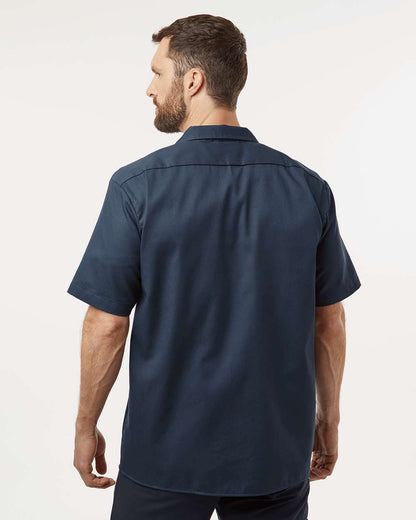 Man wearing a navy blue short-sleeve shirt on a white background. Dickie's Men's Shirt Sleeve Work Shirt, Embroidered by Helmsman Stitch Co.