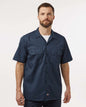 Man wearing a navy short-sleeve shirt on a white background. Dickie's Men's Shirt Sleeve Work Shirt, Embroidered by Helmsman Stitch Co.