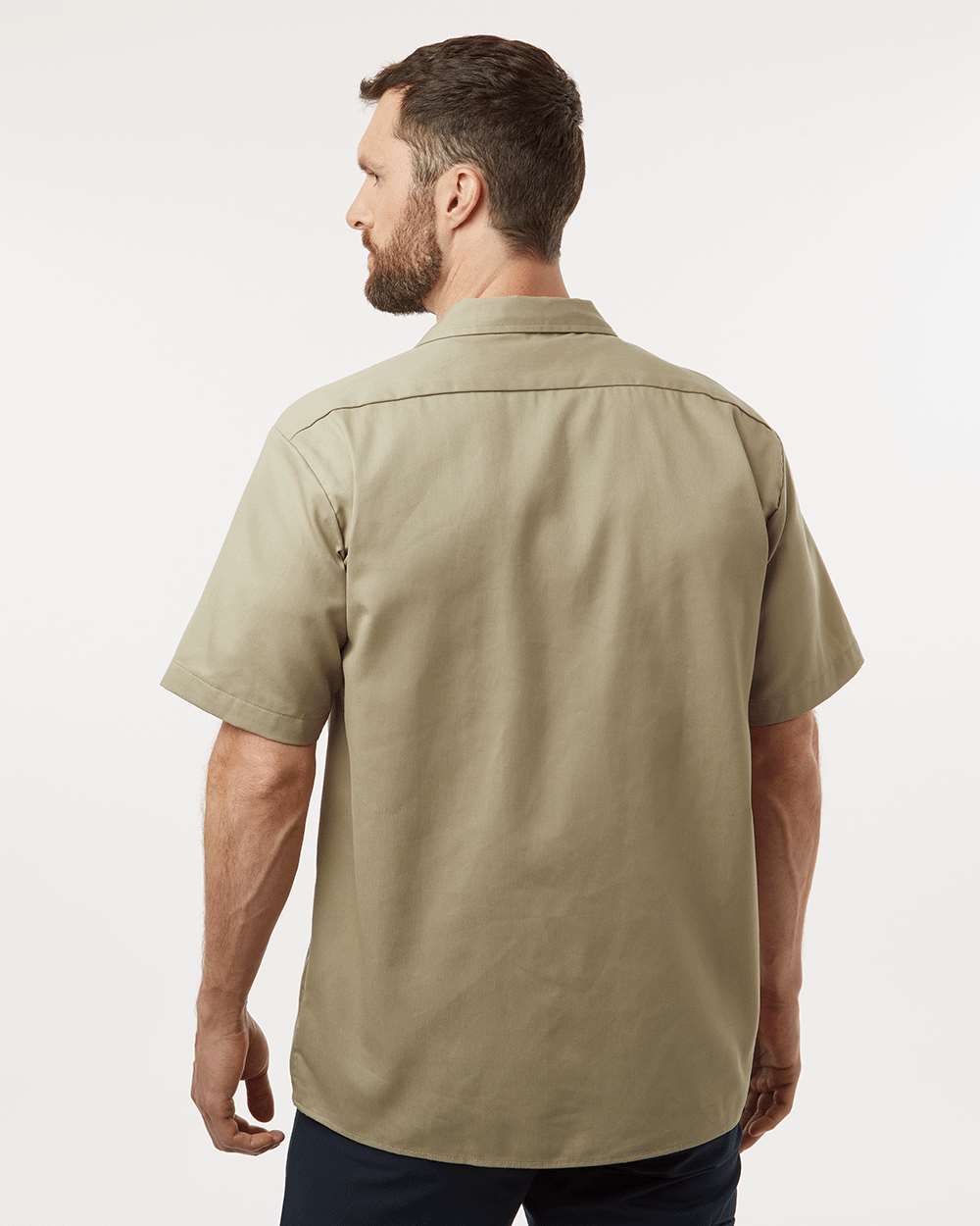 Man wearing a beige short-sleeve shirt on a white background. Dickie's Men's Shirt Sleeve Work Shirt, Embroidered by Helmsman Stitch Co.