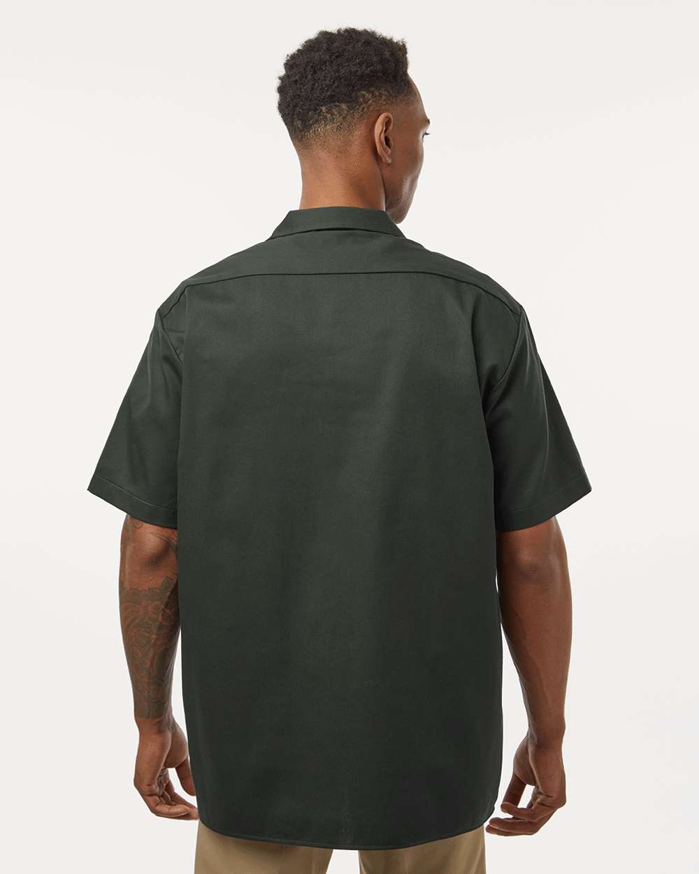 Man wearing a dark green short-sleeve shirt on a white background. Dickie's Men's Shirt Sleeve Work Shirt, Embroidered by Helmsman Stitch Co.