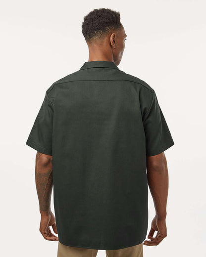 Man wearing a dark green short-sleeve shirt on a white background. Dickie's Men's Shirt Sleeve Work Shirt, Embroidered by Helmsman Stitch Co.