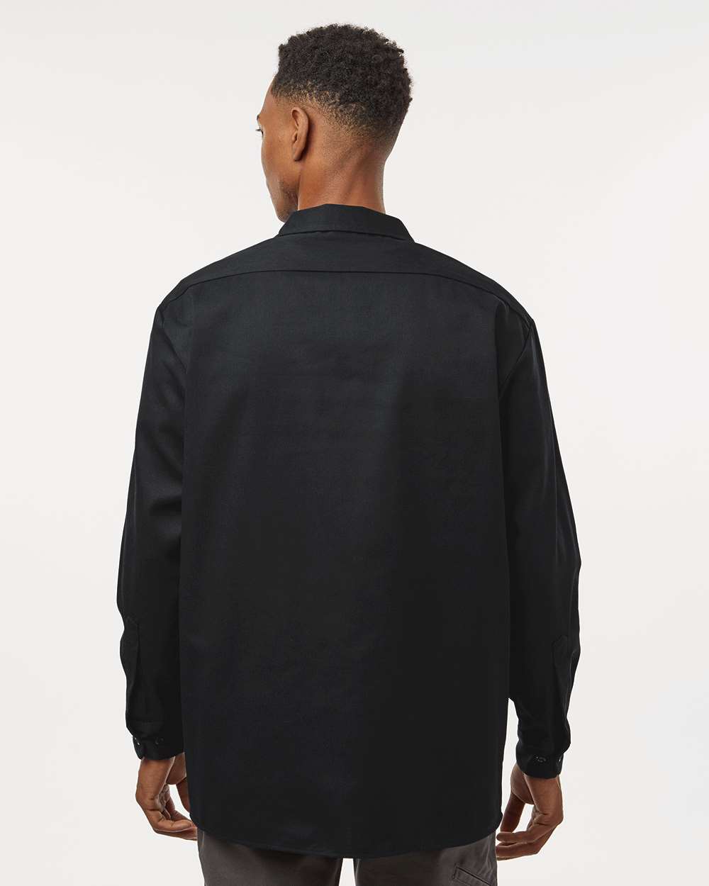 Person wearing a black shirt from behind on a white background. Dickie's Men's Long Sleeve Work Shirt, Embroidered by Helmsman Stitch Co.