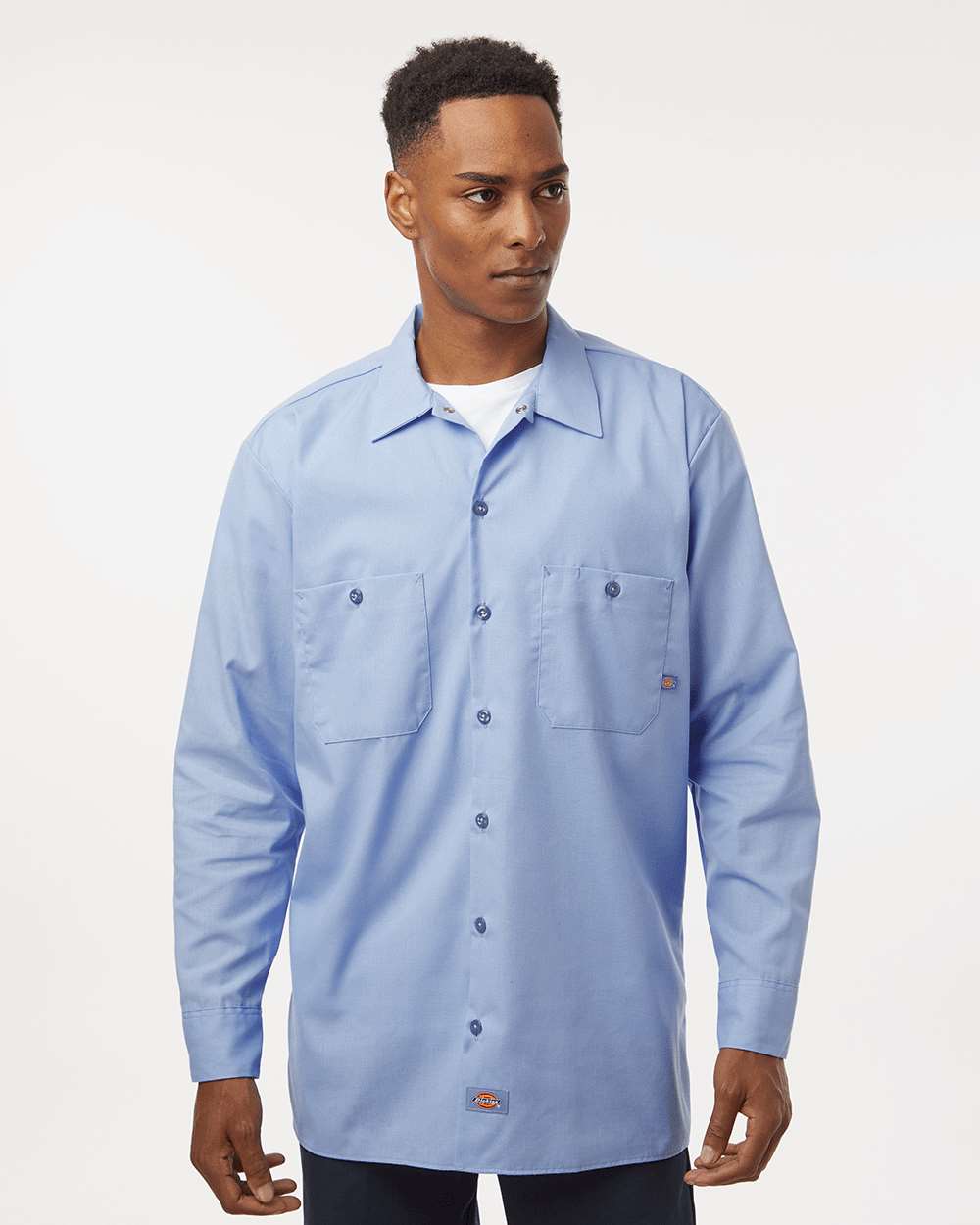 Man wearing a light blue work shirt on a white background. Dickie's Men's Industrial long Sleeve Work Shirt, Embroidered by Helmsman Stitch Co.