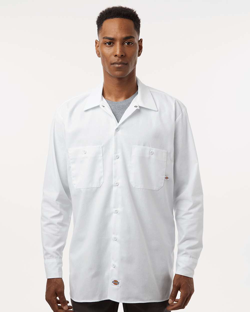 Man wearing a white long-sleeve shirt on a plain background. Dickie's Men's Industrial long Sleeve Work Shirt, Embroidered by Helmsman Stitch Co.