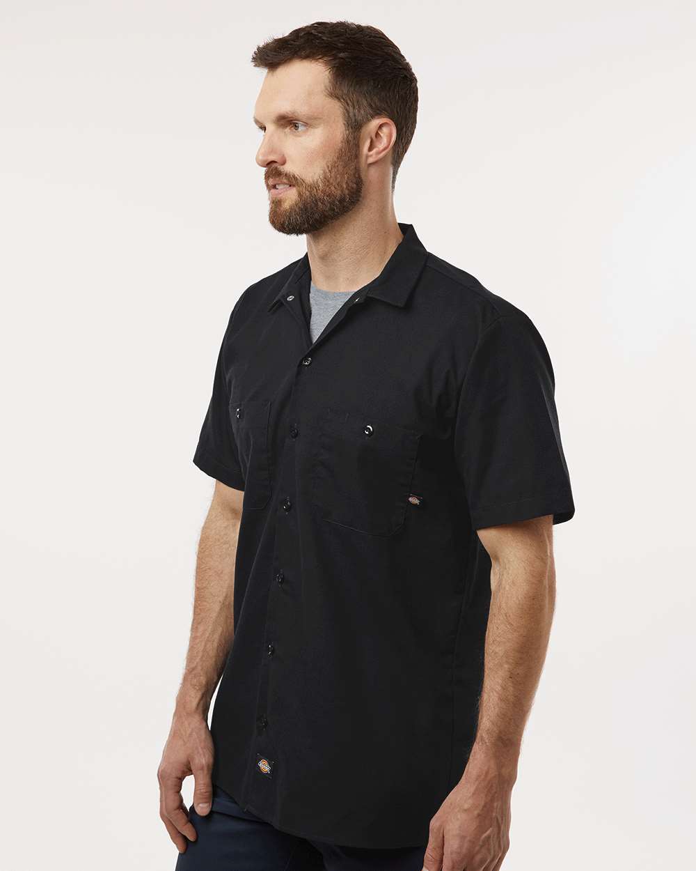 Man wearing a black short-sleeve shirt on a white background. Dickie's Men's Industrial Short Sleeve Work Shirt, Embroidered by Helmsman Stitch Co.