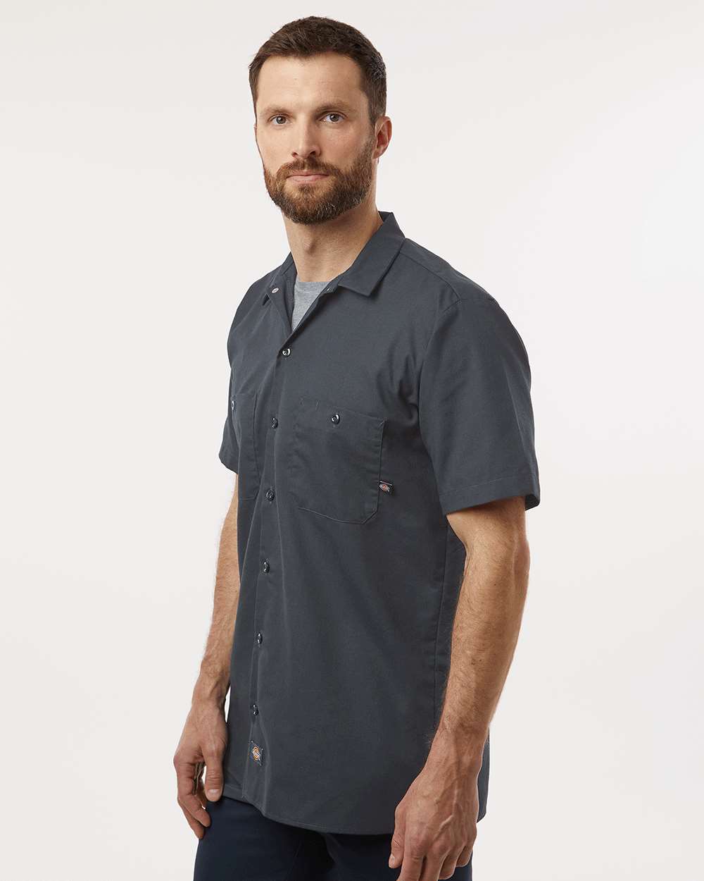 Man wearing a dark gray short-sleeve shirt on a white background. Dickie's Men's Industrial Short Sleeve Work Shirt, Embroidered by Helmsman Stitch Co.