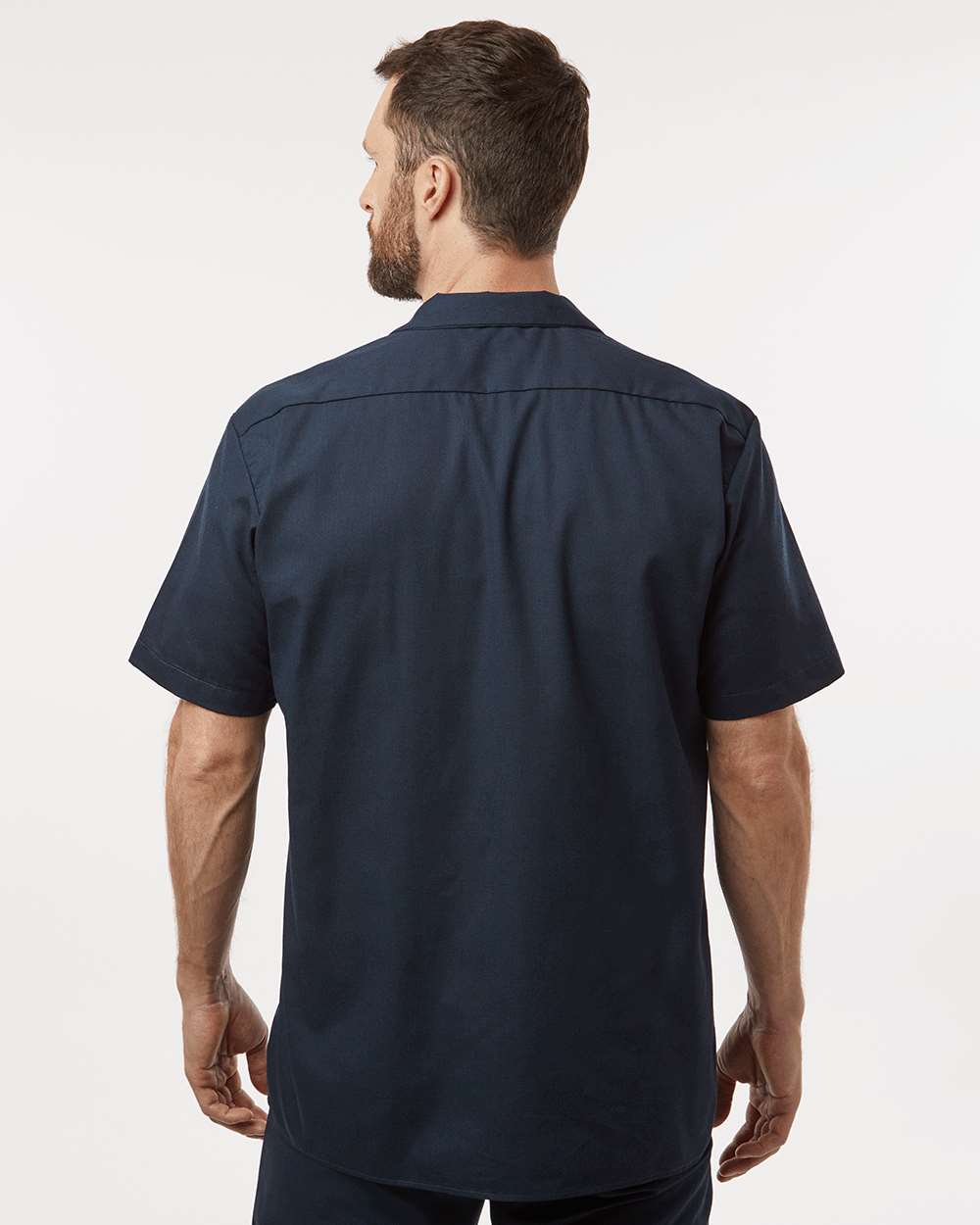 Man wearing a navy blue short-sleeve shirt on a white background. Dickie's Men's Industrial Short Sleeve Work Shirt, Embroidered by Helmsman Stitch Co.