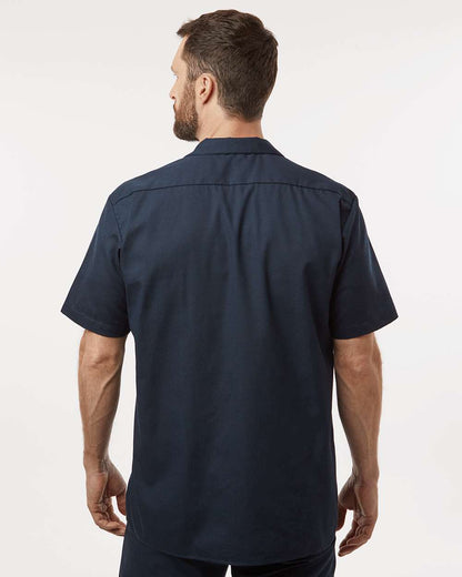 Man wearing a navy blue short-sleeve shirt on a white background. Dickie's Men's Industrial Short Sleeve Work Shirt, Embroidered by Helmsman Stitch Co.