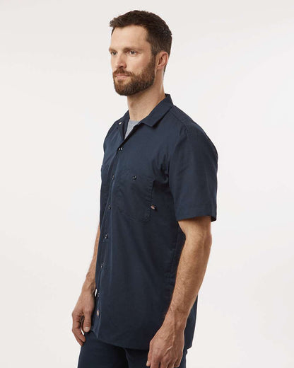 Man wearing a navy blue shirt on a white background. Dickie's Men's Industrial Short Sleeve Work Shirt, Embroidered by Helmsman Stitch Co.