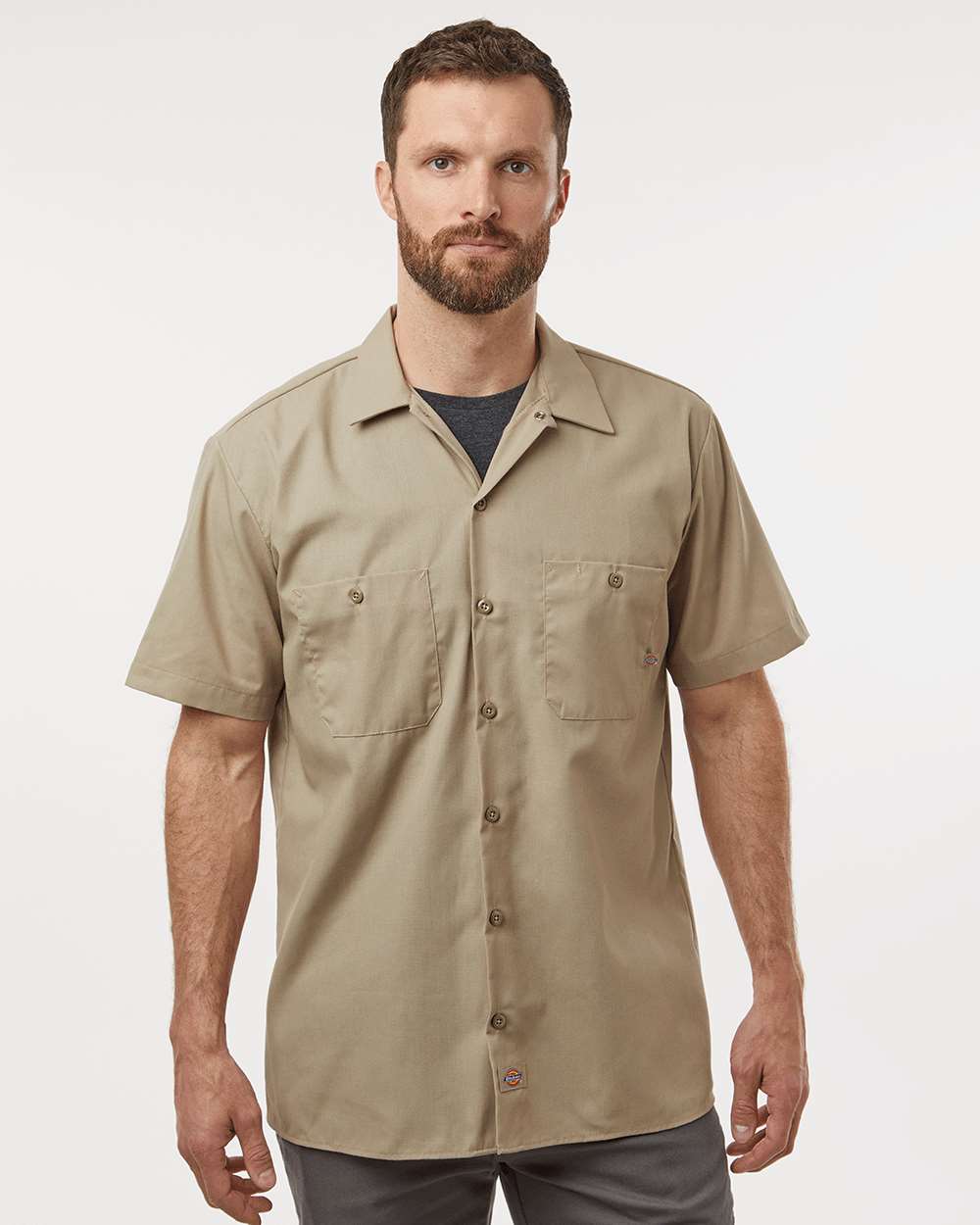 Man wearing a beige short-sleeve shirt on a white background. Dickie's Men's Industrial Short Sleeve Work Shirt, Embroidered by Helmsman Stitch Co.