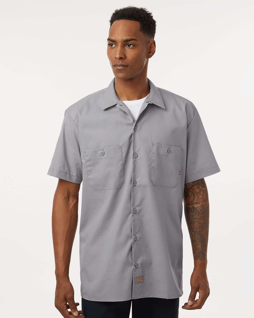 Man wearing a gray short-sleeve button-up shirt on a white background. Dickie's Men's Industrial Short Sleeve Work Shirt, Embroidered by Helmsman Stitch Co.