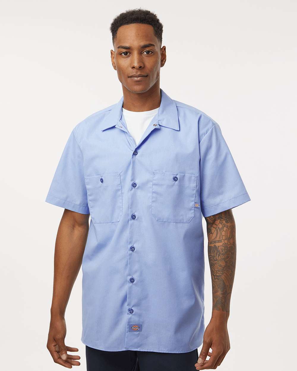 Man wearing a light blue short-sleeve button-up shirt on a white background. Dickie's Men's Industrial Short Sleeve Work Shirt, Embroidered by Helmsman Stitch Co.