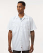Man wearing a white short-sleeve button-up shirt on a plain background. Dickie's Men's Industrial Short Sleeve Work Shirt, Embroidered by Helmsman Stitch Co.